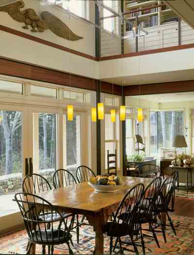 “We like the design tension between the traditional and the contemporary,” architect Matthew Elliott says. “The glass is a beautiful counterpoint to the home’s historic elements.” The eagle above the dining table is a stern board from an 1830s ship.